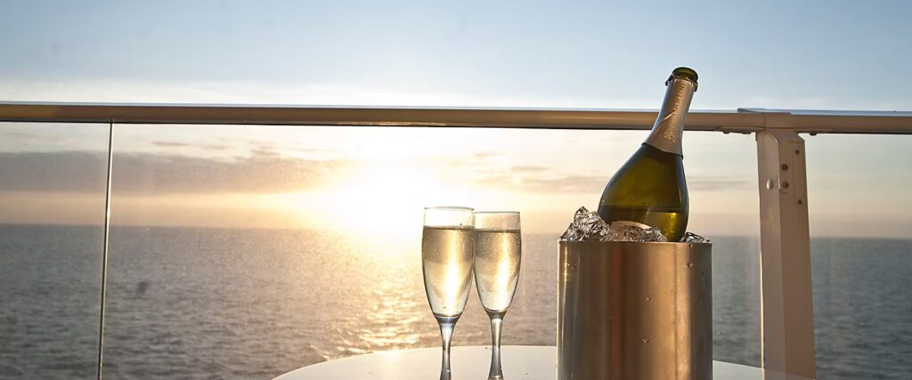 Private cruise ship balcony at sunset with champagne glasses